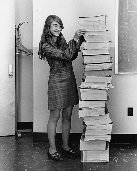 Margaret Hamilton standing beside the code she and team wrote for the apollo missions